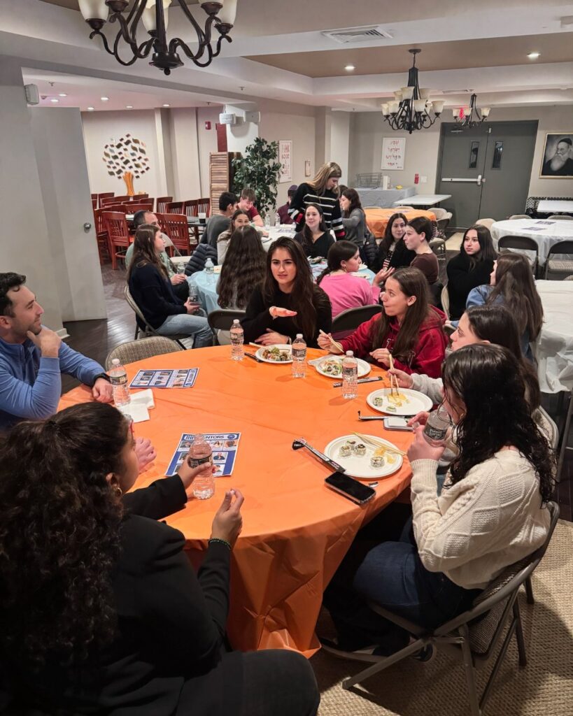 Penn JHP students in conversation with JBN professionals around a table at a Meet and Mentor networking event