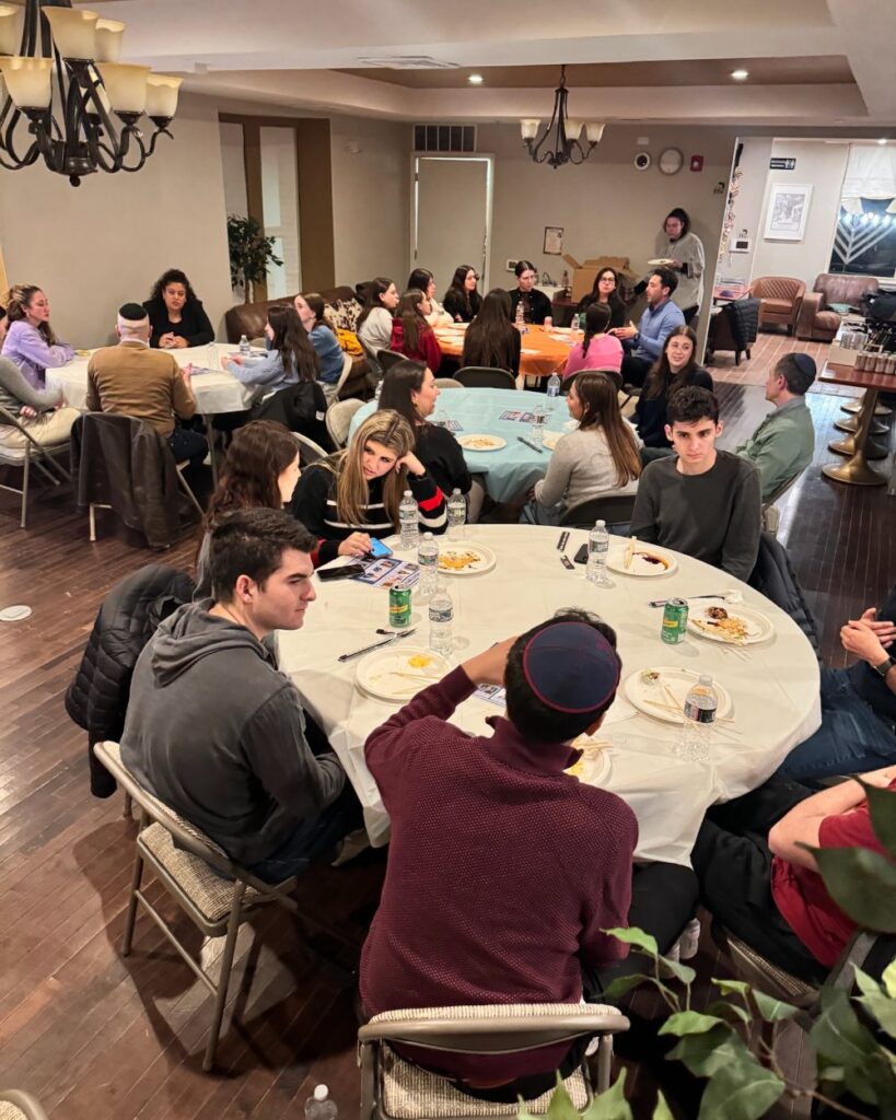 Penn JHP students networking with Jewish Business Network professionals across several tables at a Meet and Mentor event