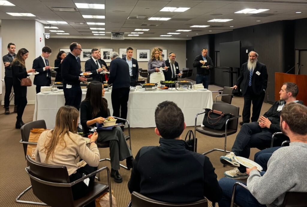 Penn JHP students and mentors in a breakout discussion circle at a New York firm during the mentoring retreat